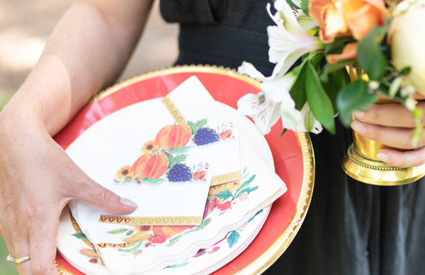 Woman holding florals and thankgiving plates